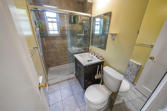 bathroom with tile patterned flooring, vanity, toilet, and a shower with shower door