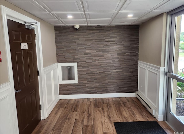 unfurnished room featuring dark hardwood / wood-style flooring, a baseboard radiator, and coffered ceiling