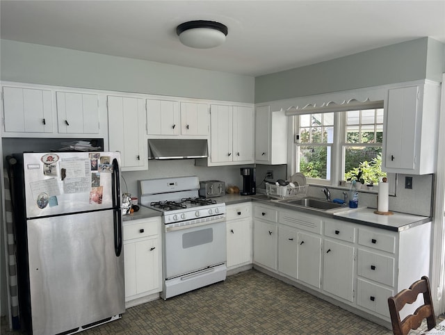 kitchen with stainless steel fridge, sink, white cabinets, and white range with gas stovetop