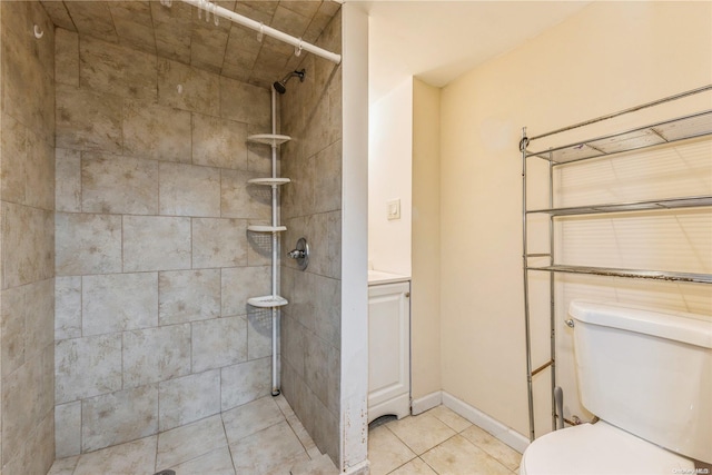 bathroom with toilet, tiled shower, and tile patterned floors