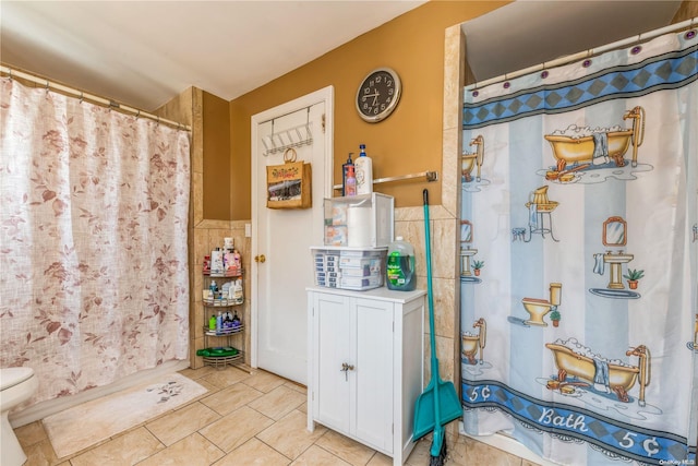 bathroom with tile patterned flooring, a shower with shower curtain, tile walls, and toilet