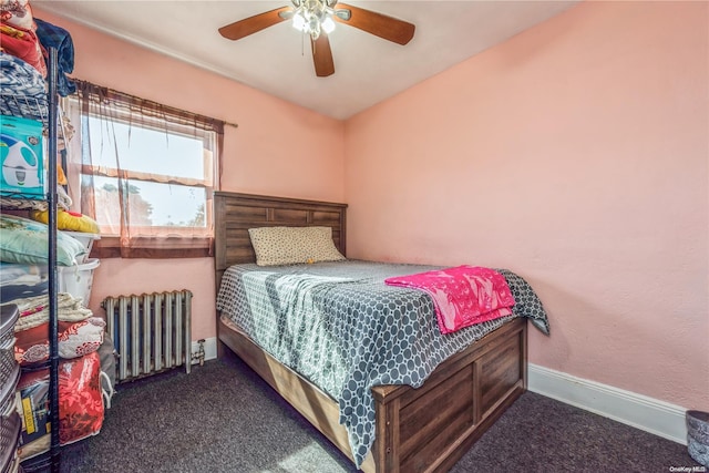 bedroom with ceiling fan, dark carpet, and radiator