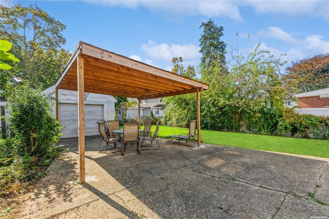 view of patio / terrace with an outbuilding, a garage, and a carport