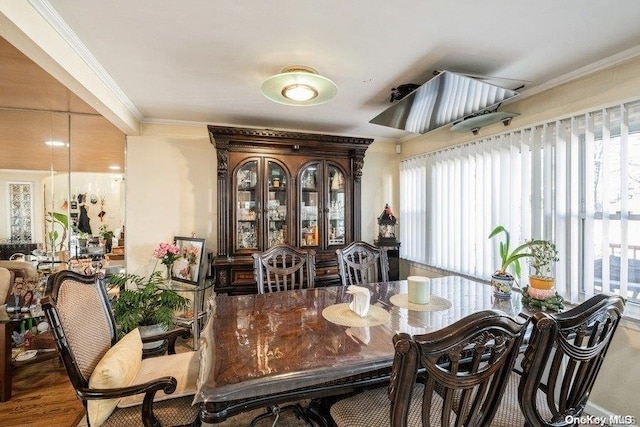 dining room featuring wood-type flooring, a wealth of natural light, and ornamental molding