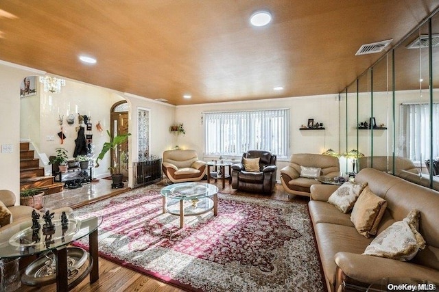 living room featuring wood-type flooring and crown molding