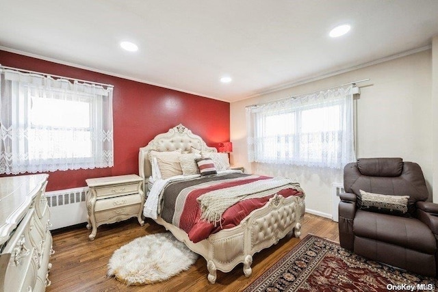 bedroom with radiator, wood-type flooring, and ornamental molding