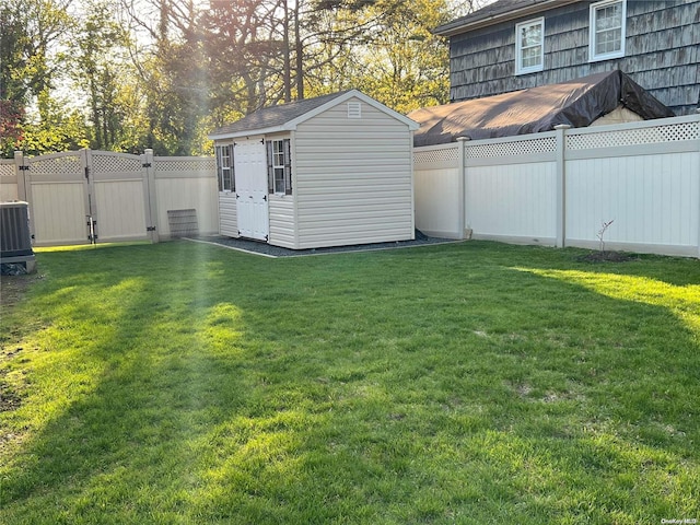 view of yard with central AC and a shed