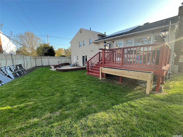 rear view of property featuring a wooden deck and a yard