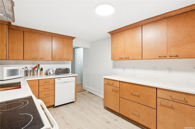 kitchen with white appliances and light hardwood / wood-style flooring