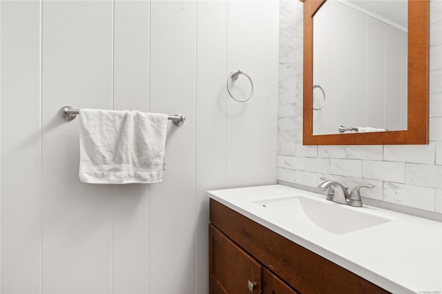 bathroom featuring vanity, tasteful backsplash, and ornamental molding