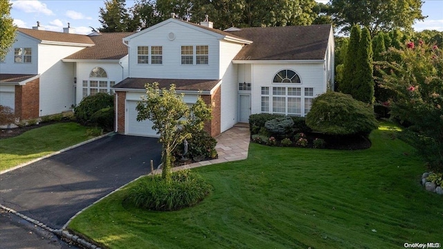 view of front of house with a garage and a front lawn