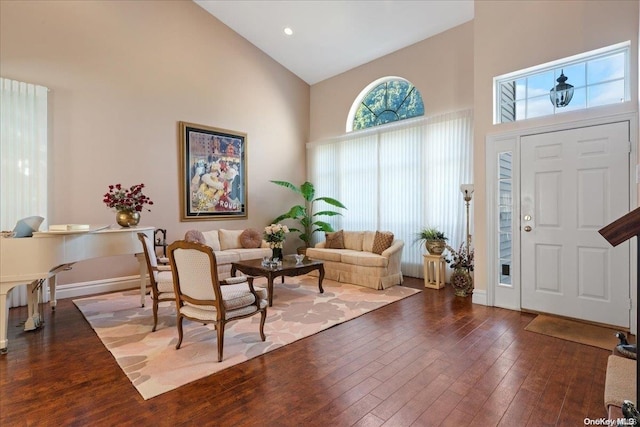 entryway with dark wood-type flooring and high vaulted ceiling