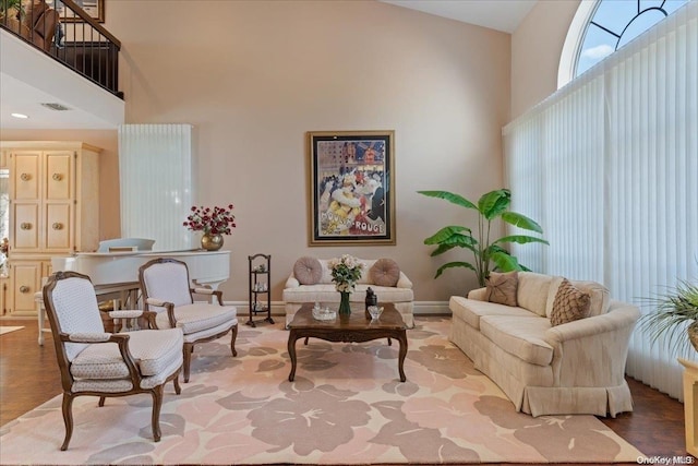 sitting room with baseboard heating, high vaulted ceiling, and light hardwood / wood-style floors