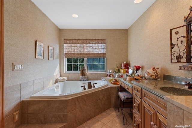 bathroom featuring vanity, tile patterned floors, and tiled tub