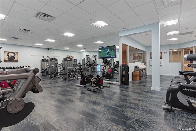 workout area featuring a paneled ceiling and dark colored carpet