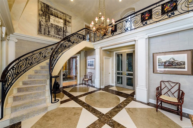 entryway with a notable chandelier, decorative columns, a high ceiling, and french doors