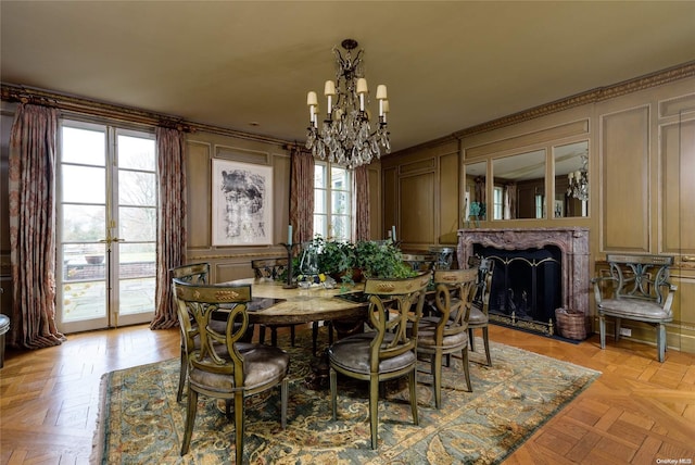 dining space with light parquet flooring, a healthy amount of sunlight, and a notable chandelier