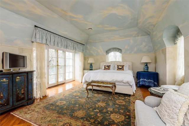 bedroom with wood-type flooring, access to outside, and vaulted ceiling