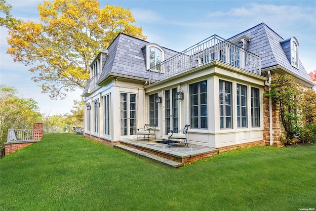 back of house with a yard, a patio, a balcony, and a sunroom