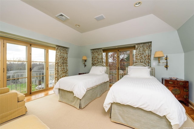 bedroom featuring hardwood / wood-style floors, access to outside, vaulted ceiling, and multiple windows