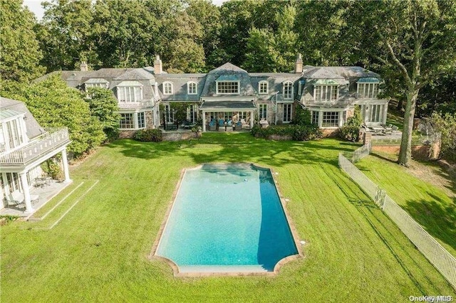 rear view of property featuring a lawn