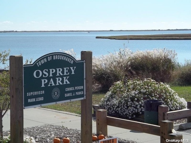 community sign featuring a water view