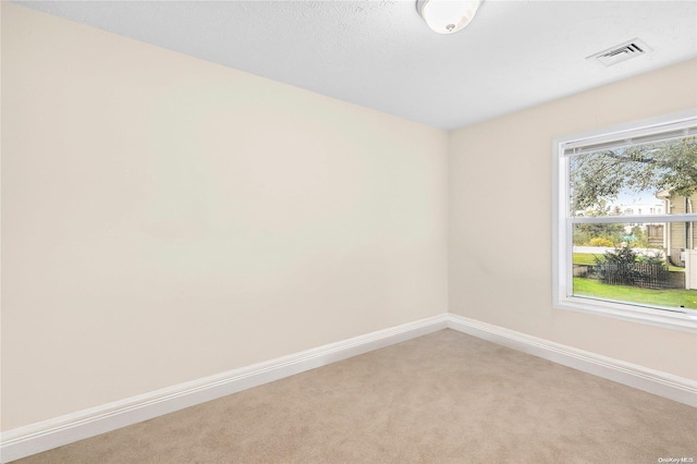 carpeted empty room featuring a textured ceiling