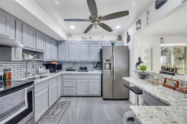 kitchen with gray cabinetry, decorative backsplash, sink, and stainless steel appliances