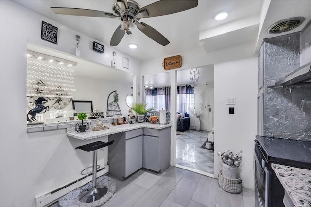 kitchen with ceiling fan, gray cabinets, and light stone counters