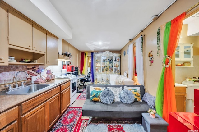 kitchen featuring electric stove, sink, and tasteful backsplash