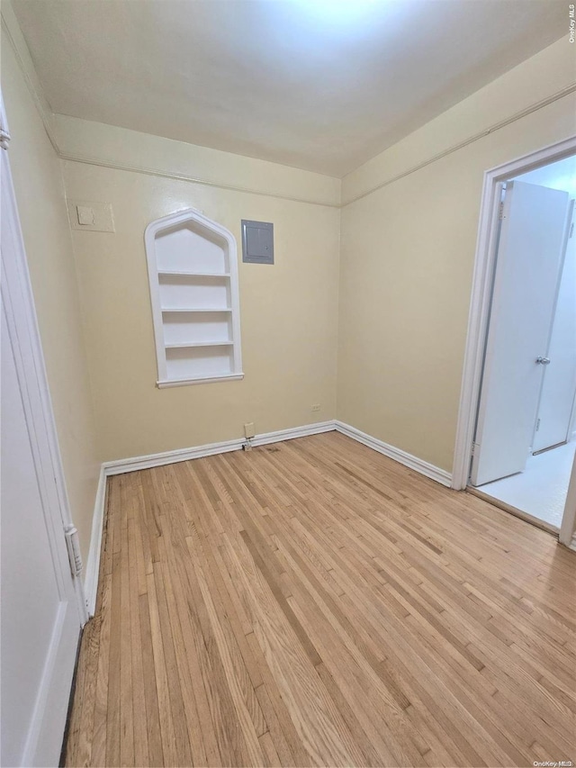 spare room with light hardwood / wood-style floors and built in features