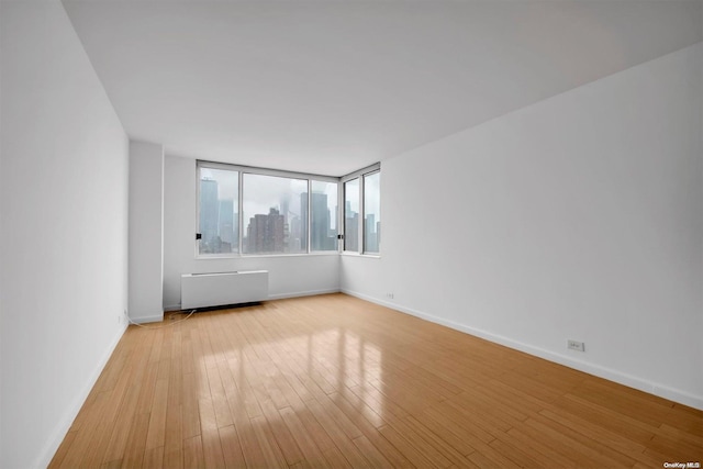 spare room with light wood-type flooring and radiator heating unit