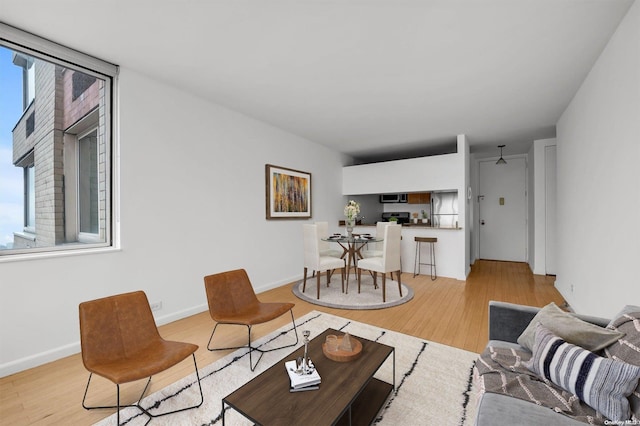 living room featuring ceiling fan and light hardwood / wood-style flooring