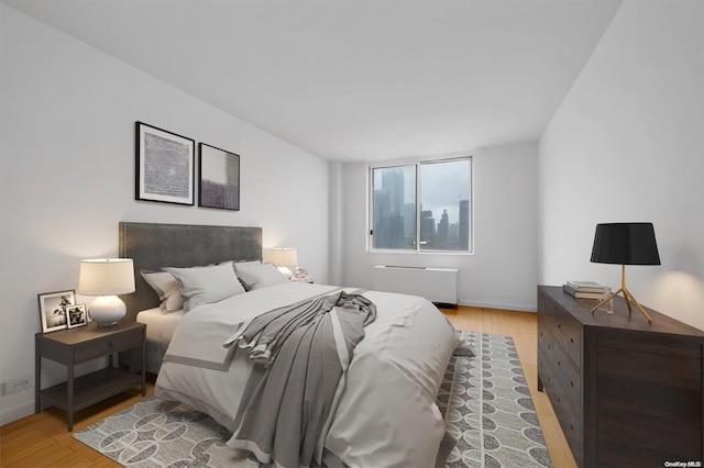 bedroom with radiator and light hardwood / wood-style floors