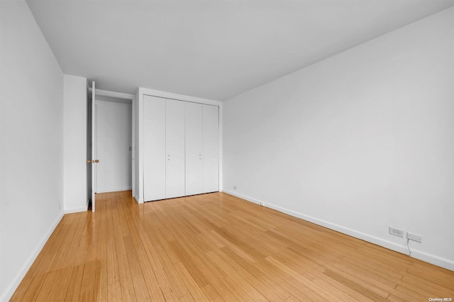 unfurnished bedroom featuring a closet and light wood-type flooring