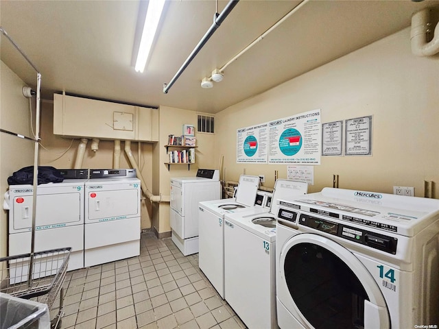 laundry area with washer and clothes dryer and light tile patterned floors