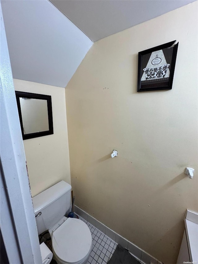 bathroom featuring tile patterned flooring, toilet, and lofted ceiling