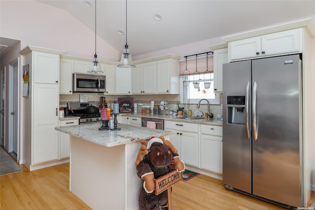 kitchen with a center island, backsplash, sink, vaulted ceiling, and stainless steel appliances