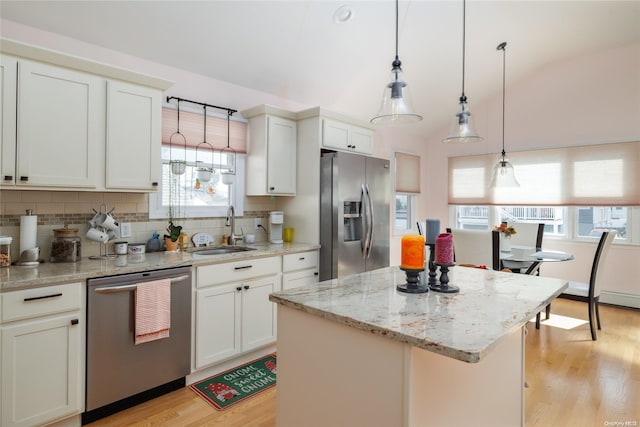 kitchen with a center island, stainless steel appliances, plenty of natural light, and sink