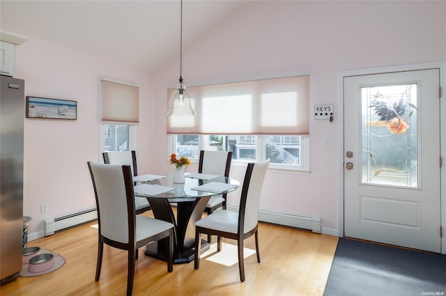 dining space featuring a baseboard radiator, lofted ceiling, and light hardwood / wood-style floors