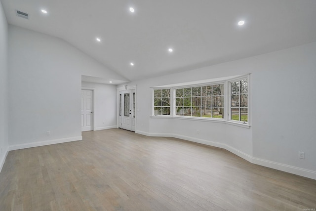 empty room with light wood-type flooring, baseboards, recessed lighting, visible vents, and lofted ceiling