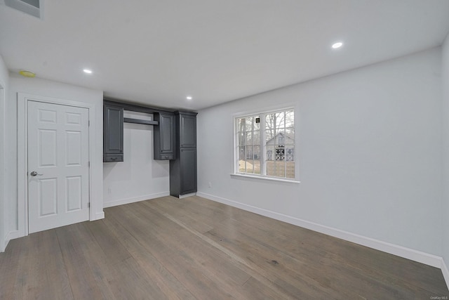 unfurnished bedroom with visible vents, baseboards, recessed lighting, and wood finished floors