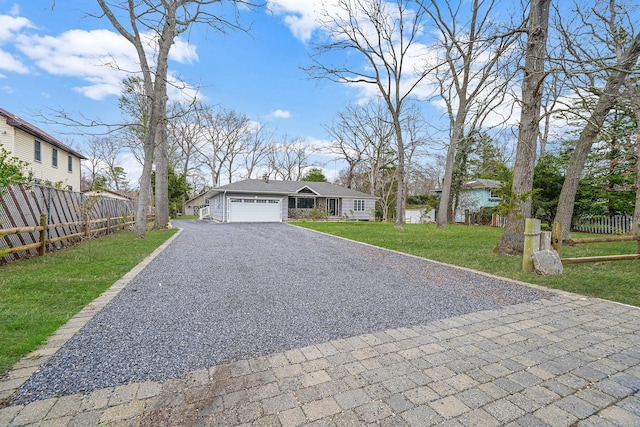 ranch-style house with a garage, aphalt driveway, fence, and a front lawn