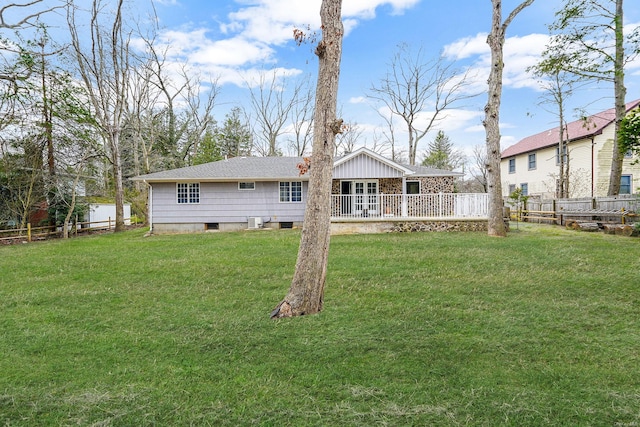 rear view of house with a yard and fence