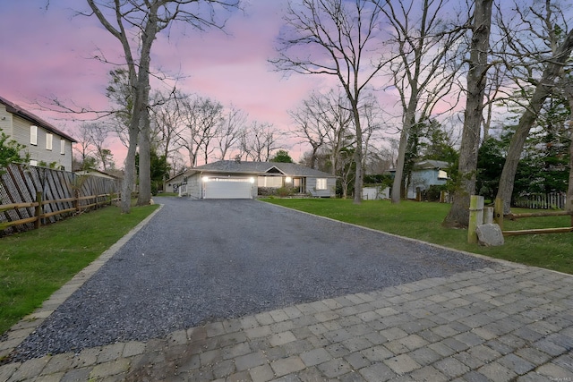 view of front of home featuring a yard, driveway, and fence