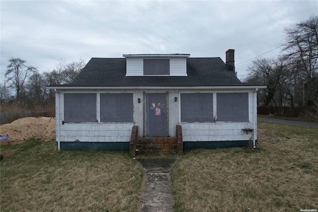 bungalow with a sunroom and a front lawn