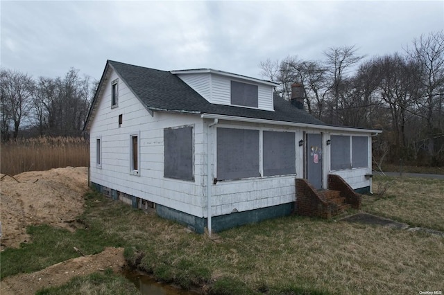 view of front facade with a sunroom and a front lawn