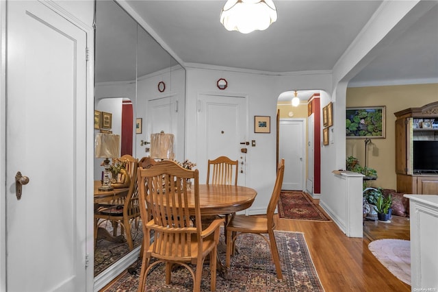 dining room with hardwood / wood-style floors and ornamental molding