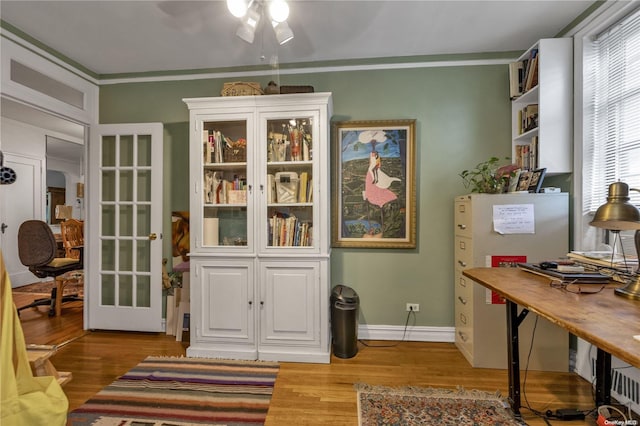 interior space with french doors, wood-type flooring, and ornamental molding