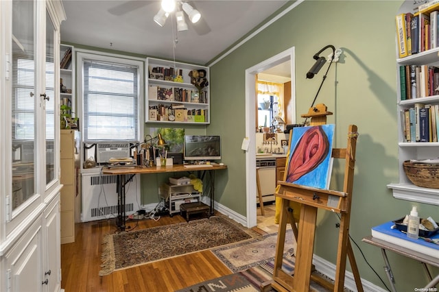 home office featuring radiator, ornamental molding, cooling unit, ceiling fan, and wood-type flooring